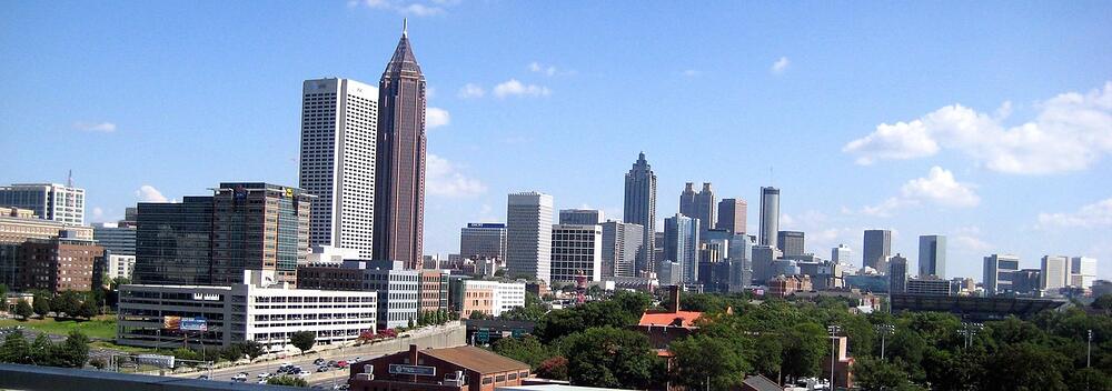 The Midtown Atlanta skyline standing above rooftops and trees